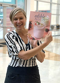 Marianne Malina gets her copy of Edible Austin